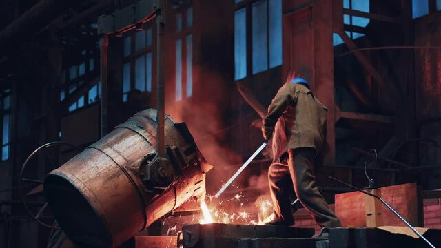 Process of casting molten metal or iron into mold from ladle. Steel foundry factory, heavy industry.