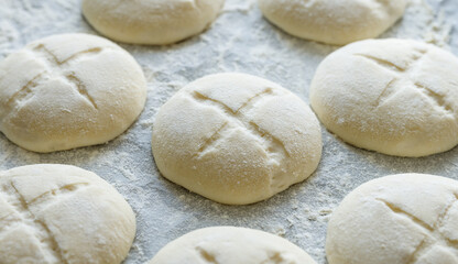 Fototapeta na wymiar Raw homemade yeast rolls prepared for baking, close-up