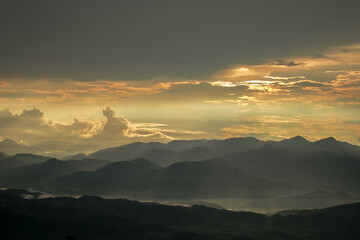Obraz premium Golden Sunset Landscape with mountains and fog