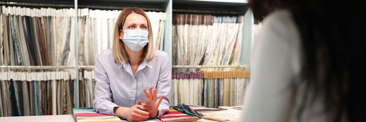 Salesman in medical mask advises client closeup