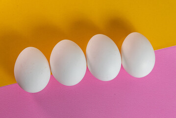 Eggs on the yellow and pink background