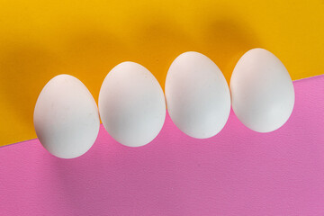 Eggs on the yellow and pink background