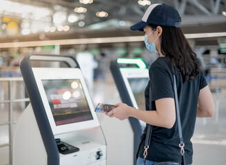 Female hand using the auto self service check-in for get the boarding pass at the airport.