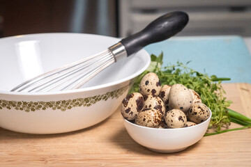 Farm to table home chef quail eggs with mixing bowl whisk and herbs for cooking healthy gourmet meals