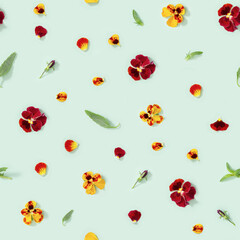 Seamless pattern with natural blossom flowers pansy, buds, leaves, petals on green paper. Small bright blooms.