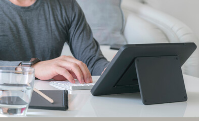 Cropped shot of man hand working with tablet at home.