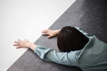 白と黒の床で這いつくばる女性社員