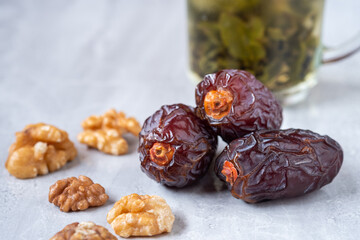 The large dates (Medjool) with walnut and tea on a marble floor.
