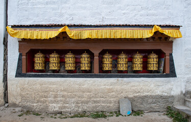 Rows of prayer wheel on the wall in Kathmandu city of Nepal. The words mantra "Om Mani Padme Hum" is written in Sanskrit on the outside of the wheel.