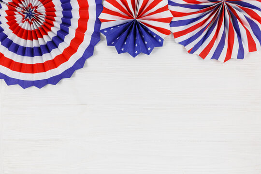 Decorations for 4th of July day of American independence, flag,  straws, paper fans. USA holiday decorations on a white wooden background, top view, flat lay	