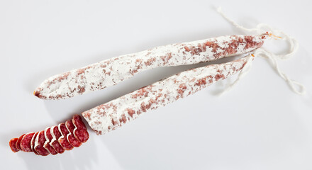 Close-up of spiced spanish fuet sausages at white background, nobody