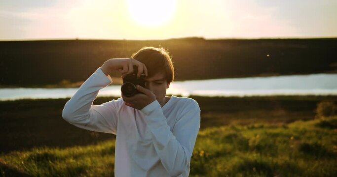 Man of young appearance, photographing, looking for a good angle for a shot.