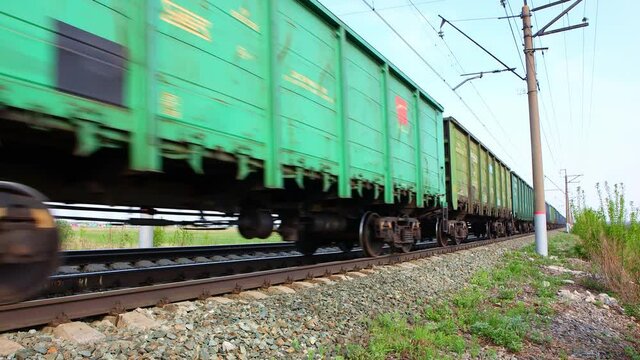 The movements of a freight train on the railway tracks. Close angle. The train passes at high speed.