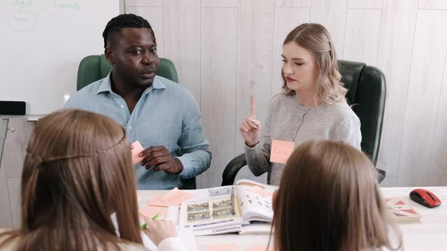 Africanm american man and female teacher teaching English on private lesson