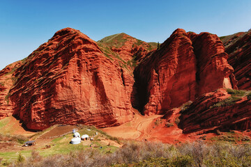 Jety-Oguz gorge Canyon, cliffs of seven bulls. Red rocks, erosion in clay, blue sky and steppe...