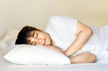 asian man sleep on pillow in bed room for relax