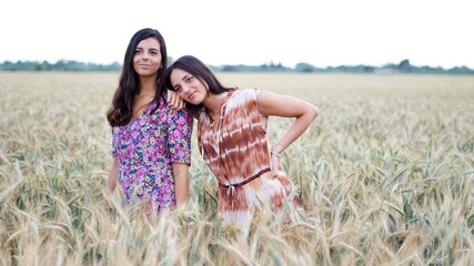 smiling standing girls in a wheat field