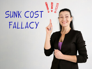  SUNK COST FALLACY exclamation marks phrase on the gray wall