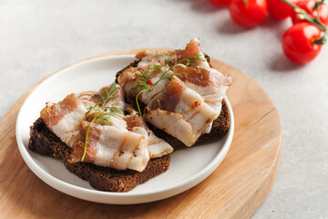 Two bread slices with salted pork bacon or lard, traditional snacks to Ukrainian borscht