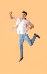 Fototapeta na wymiar Jumping young man on color background
