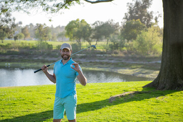 Portrait of happy smilin golfer hitting golf shot with club on course.