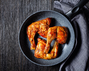 Chicken leg quarters on a frying pan, top view
