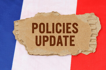 Against the background of the French flag lies cardboard with the inscription - Policies Update