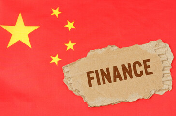 Against the background of the Chinese flag lies cardboard with the inscription - finance