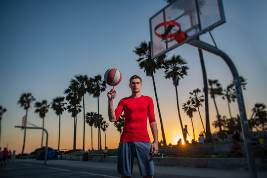 hold basketball ball on Venice beach basketball court. Hand spinning basket ball. Balancing basketball on finger.