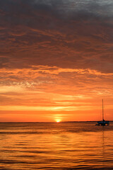 Fototapeta na wymiar Ocean sea water. Sailing and yachting. Boat on water at sunset. Sailboats with sails.