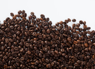 Fototapeta premium Natural background of roasted coffee beans on white surface..