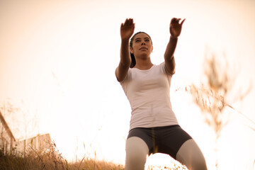 Woman working squats in nature.  Training for legs.