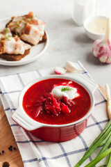 Delicious fresh red borscht, dark bread with lard and salt on kitchen table. 