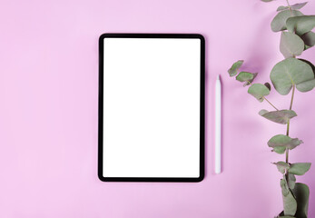iPad pro with white screen on pink color background. Flatlay. Office background	