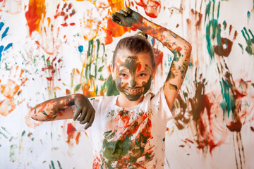Portrait of happy young child playing with watercolor