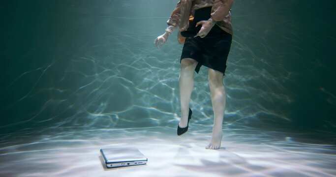 Cinematic view of beautiful young boss business woman in suit taking uncomfortable shoes off under water slow motion