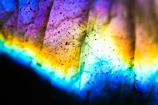 Detail of colorful multicolored (blue, yellow, purple, cyan) labradorite gemstone. Close-up of the texture