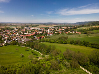 Fototapeta na wymiar aerial drone flight photo of green hills, meadows and fresh forest in Lower Austria at the edge of Vienna Woods on a sunny day