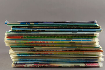 Stack of old school exercise books on a gray background.