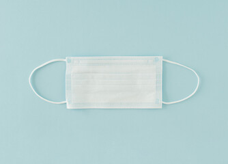 Medical mask on a blue background from CoronaVirus. Safety mask, dust protection respiratory, and a...