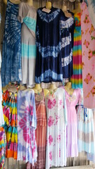 Display window with mannequins in fashionable tie dye dresses for summer season.