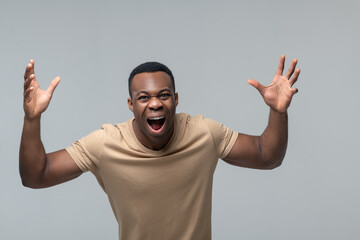 Emotional dark skinned man in cheerful mood