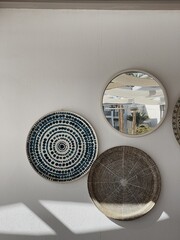 Traditional oriental ornamental ceramic plates and mirror on white wall. Beautiful decoration background