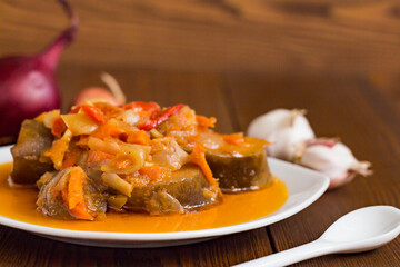 vegetable stew with eggplant, carrot and onion on a white plate closeup