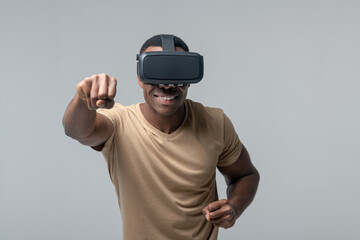 Cheerful man in VR glasses waving his fists