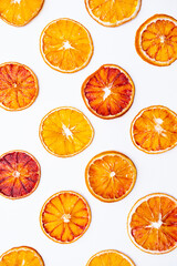Bright summer background of citrus fruits. Slices of dried red oranges on a white background.