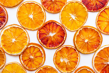 Bright summer background of citrus fruits. Slices of dried red oranges on a white background.