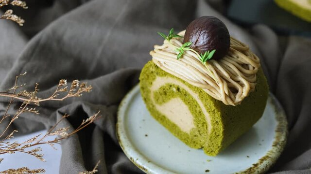 Green Tea Swiss Roll Cake With Chestnut Cream Filling Set On Cafe Table.