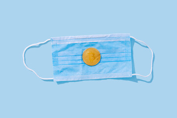 Surgical mask with rubber earhooks with bitcoin coin. Blue background