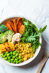 Vegan breakfast bowl - scrambled tofu, corn, beans, sweet potato and broccoli. Plant-based diet concept.